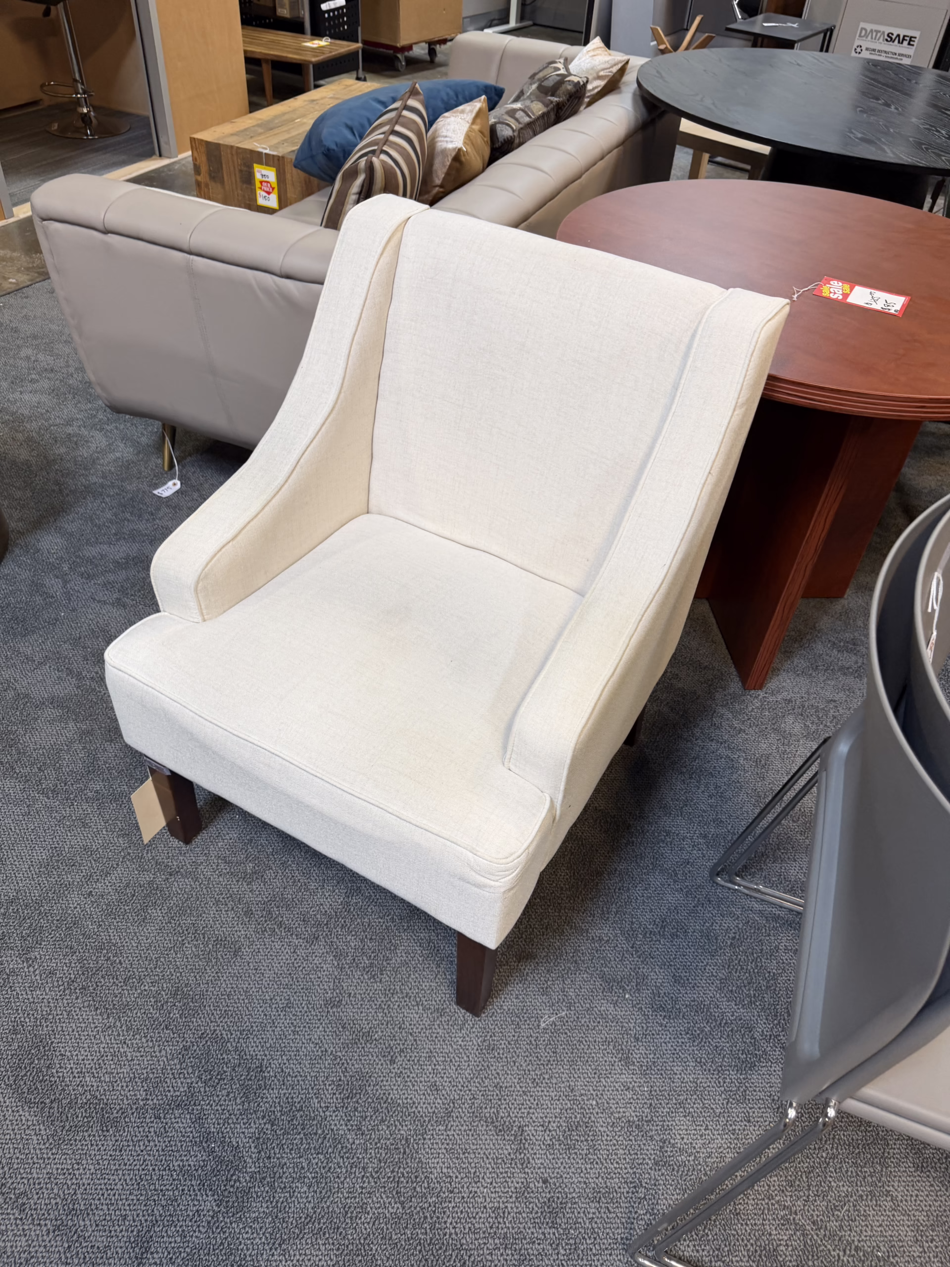 cream colored club chair with wooden legs